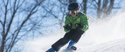 gutt med hjelp som kjører slalom. foto.
